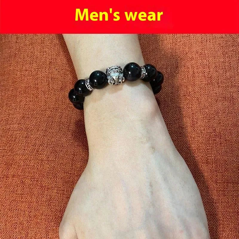Natural obsidian bead bracelet with Silver 999 details and Cloud Year Of design on a wrist.