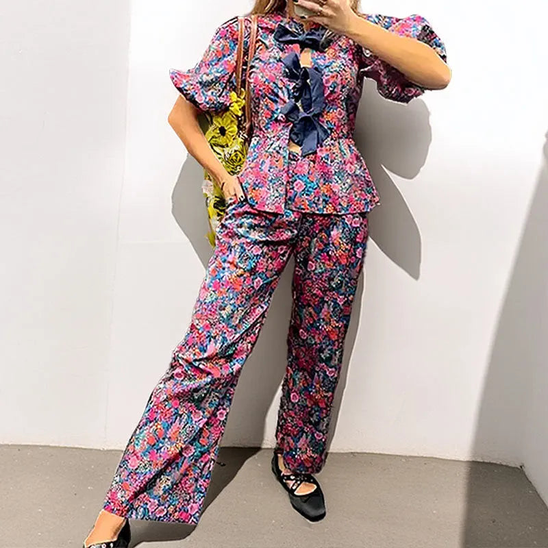 Floral print trousers suit with tie-neck blouse featuring puff sleeves and matching trousers