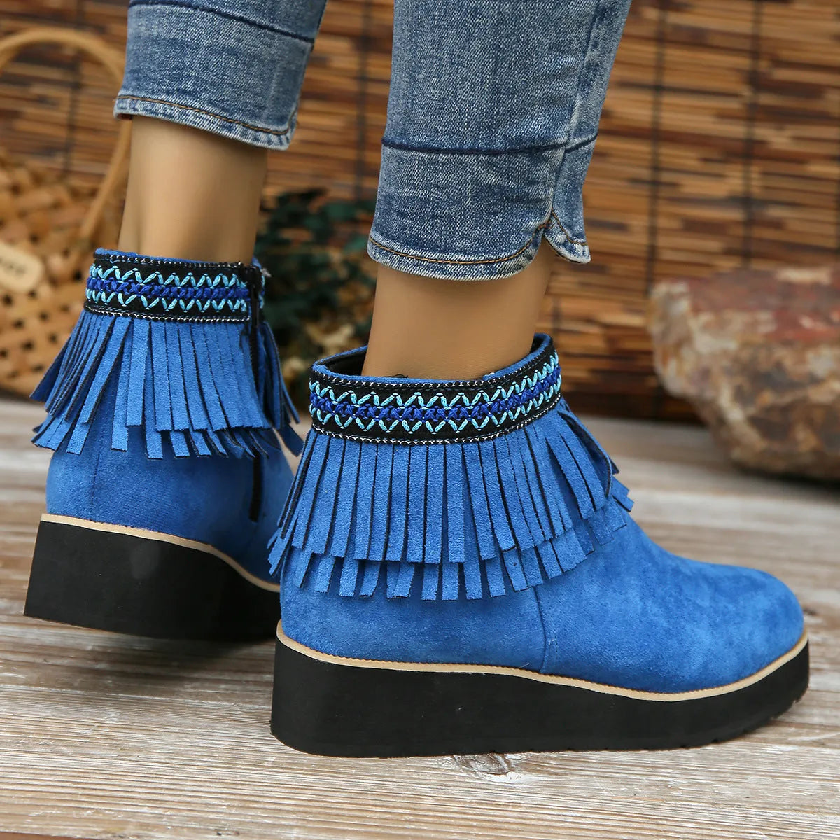Women's black suede wedge ankle boot with side zip and tassel detail on a thick rubber platform sole.