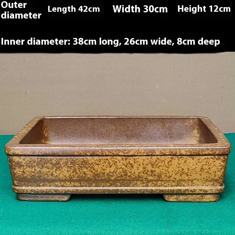 Straight-sided shallow rectangular Yixing flowerpot made from purple Zisha clay on a floor.