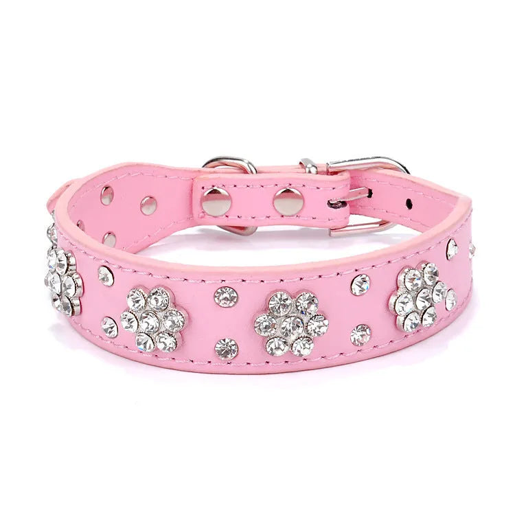 PU leather dog collar with rhinestone flower studs in black, showing metal D-ring and adjustable eyelets.