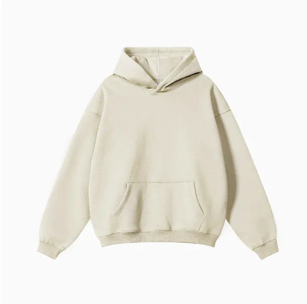 Man wearing a loose grey hooded terry cotton sweater with drop-shoulder sleeves.