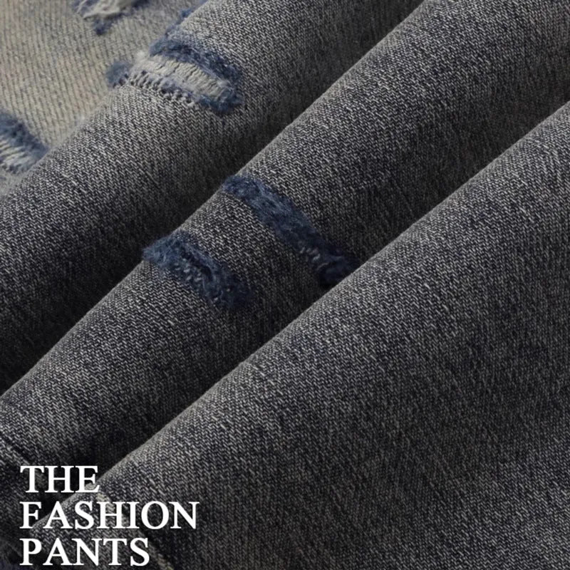 Worn looking washed-out slim fit jeans with hole patches and embroidered brand detail in old colour