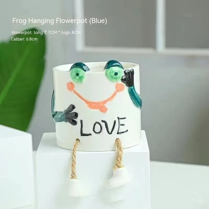 Cartoon style ceramic hanging foot flowerpot for succulent plants on a desktop.