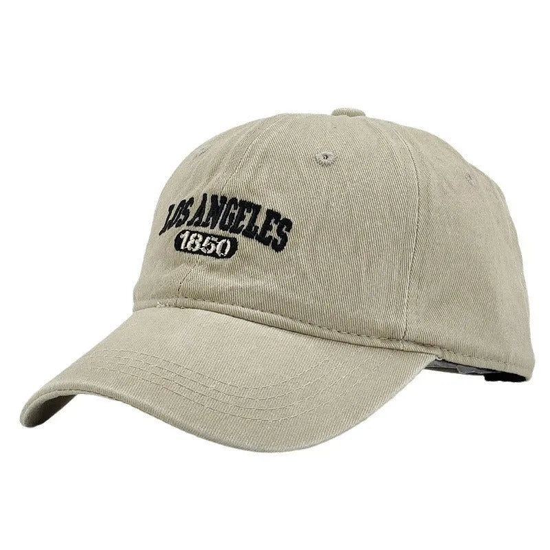 Retro personalised distressed embroidered peaked cap in beige colour with adjustable strap and conical crown.