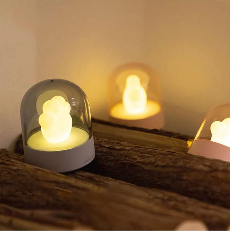 Grey cat paw USB night light with rotating illumination and music box function on wooden desk