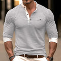 Man wearing a solid colour long sleeve cotton t-shirt in grey, showing round neck and casual fit.