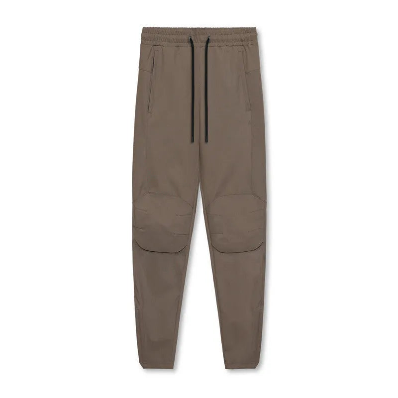 Men's grey loose-fit running pants with ankle ties on a gym floor