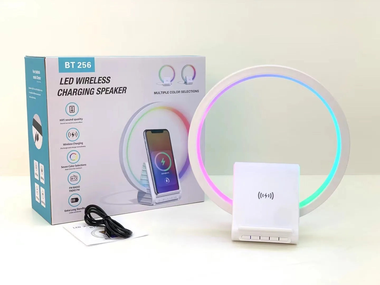 White smart Bluetooth speaker with wireless charging pad, ambience light, and card slot on a desk