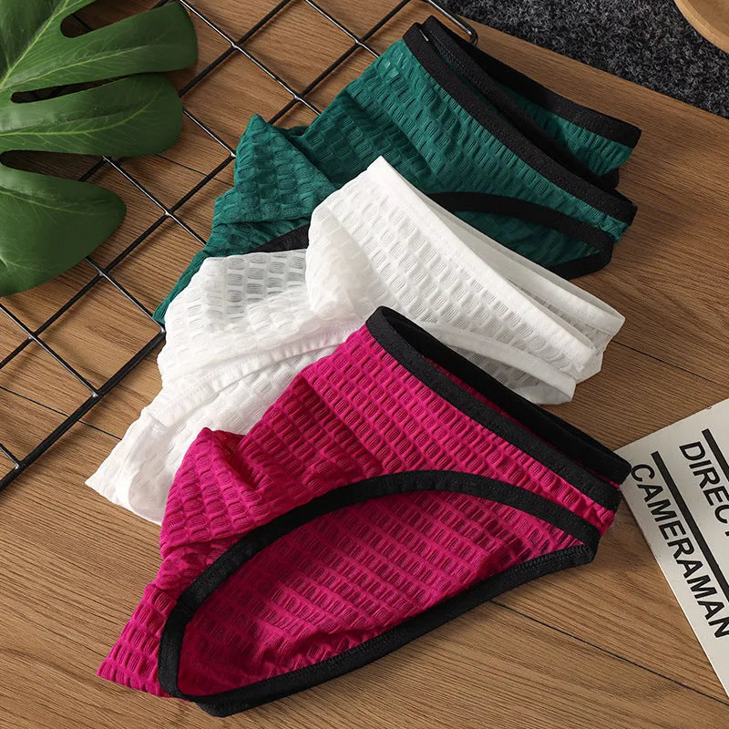 Men's low waist transparent lace underwear in multiple colours on a size chart background.