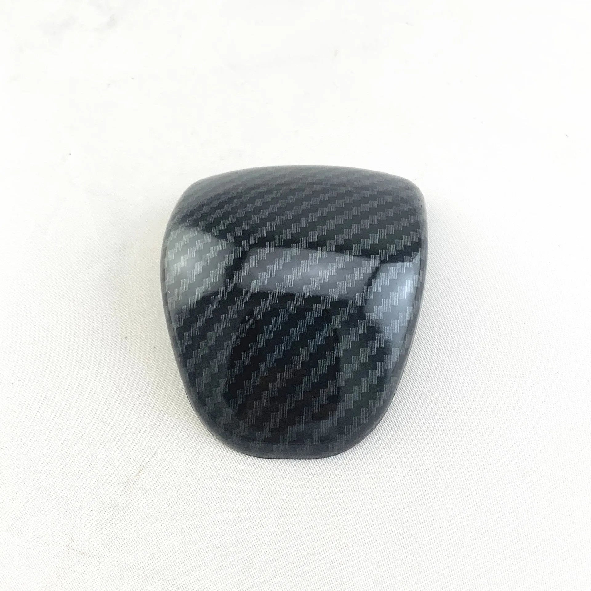 Black carbon fibre pattern gear shift cover for car interior with textured anti-slip surface