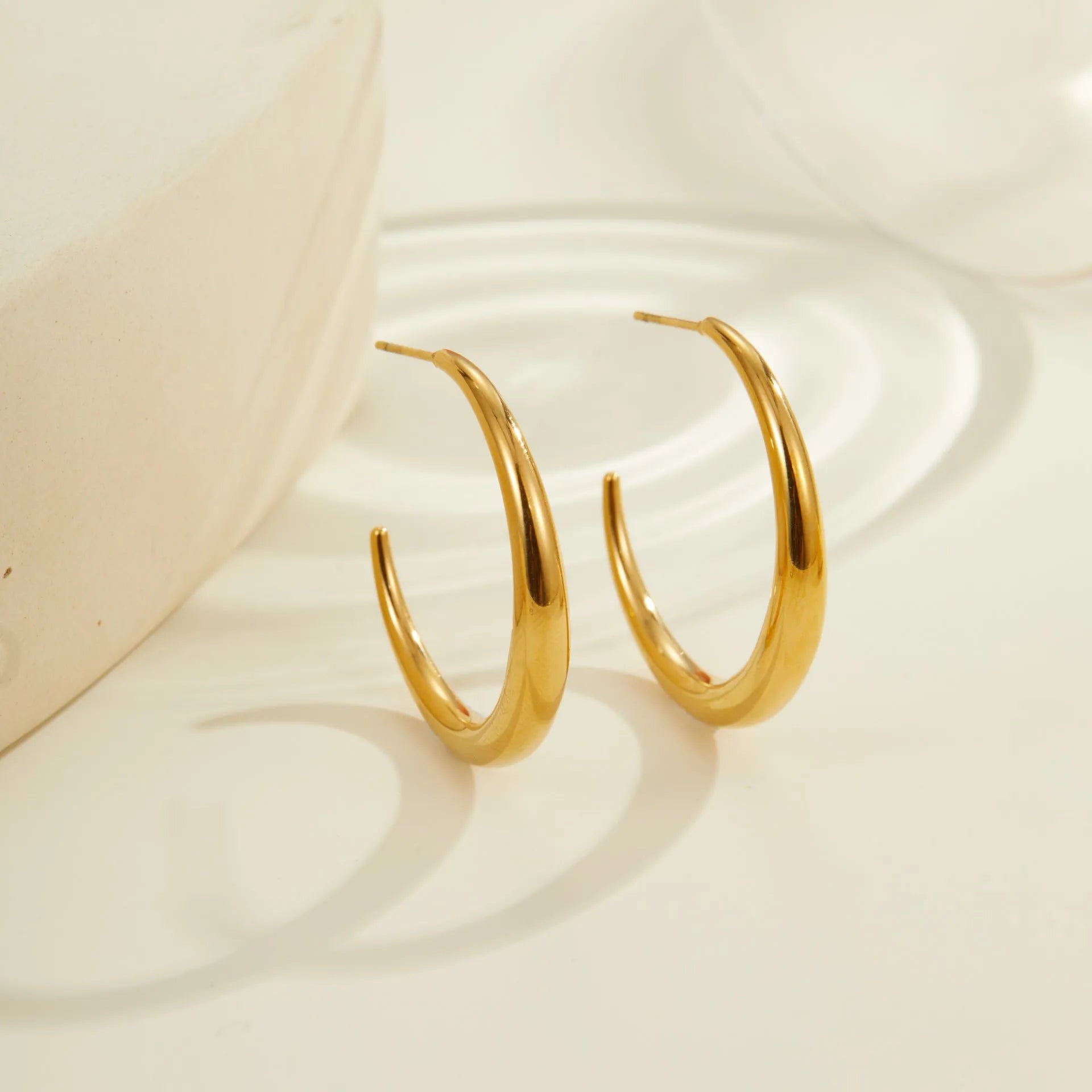 Women's stainless steel hoop earrings with 18K PVD gold plating in geometric round design