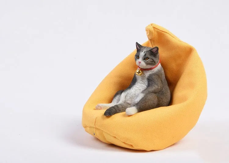 Small lazy cat car ornament and sofa, 7.5cm tall resin model on a car dashboard.