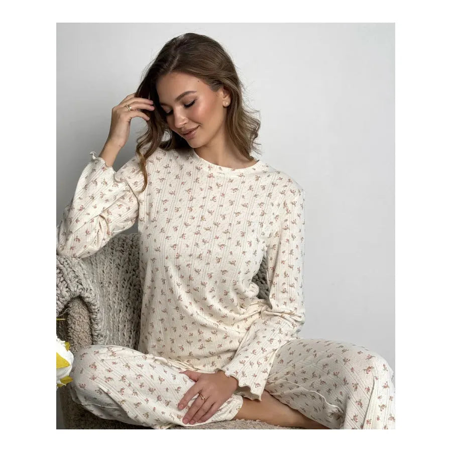 Women's white floral print suit set featuring a round neck top with bell sleeves and wide leg trousers.