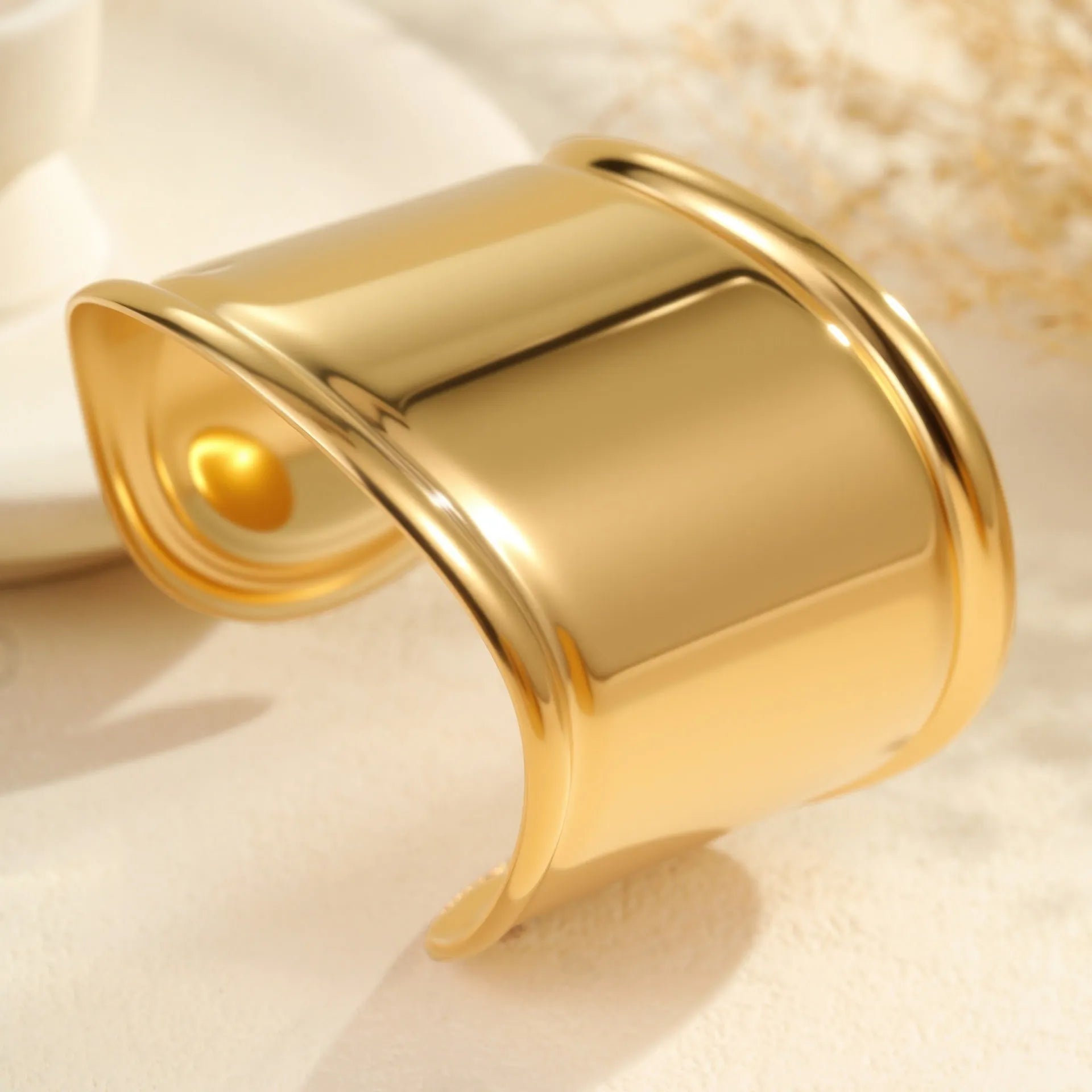 Women's wide stainless steel bracelet with 18K gold plating, geometric wave design, and niche opening closure.