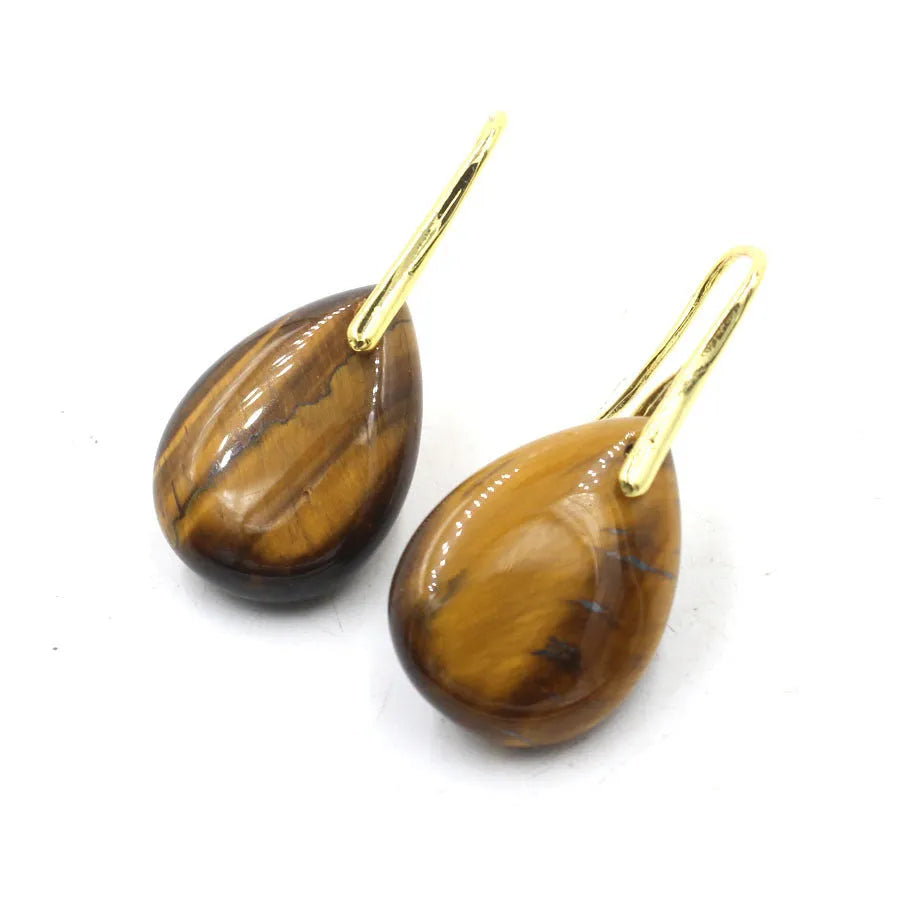 A pair of geometric water drop earrings made from crystal, shown in one of nine available colours like amethyst or obsidian.