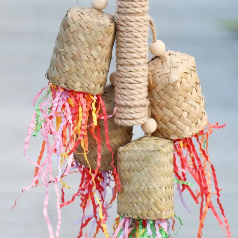 Wooden parrot toy with colourful shredded paper hanging by sisal rope
