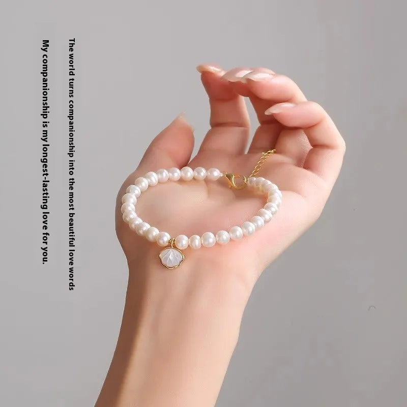 Women's freshwater pearl bracelet with fan-shaped alloy clasp, shown with both elastic and chain fastening options.