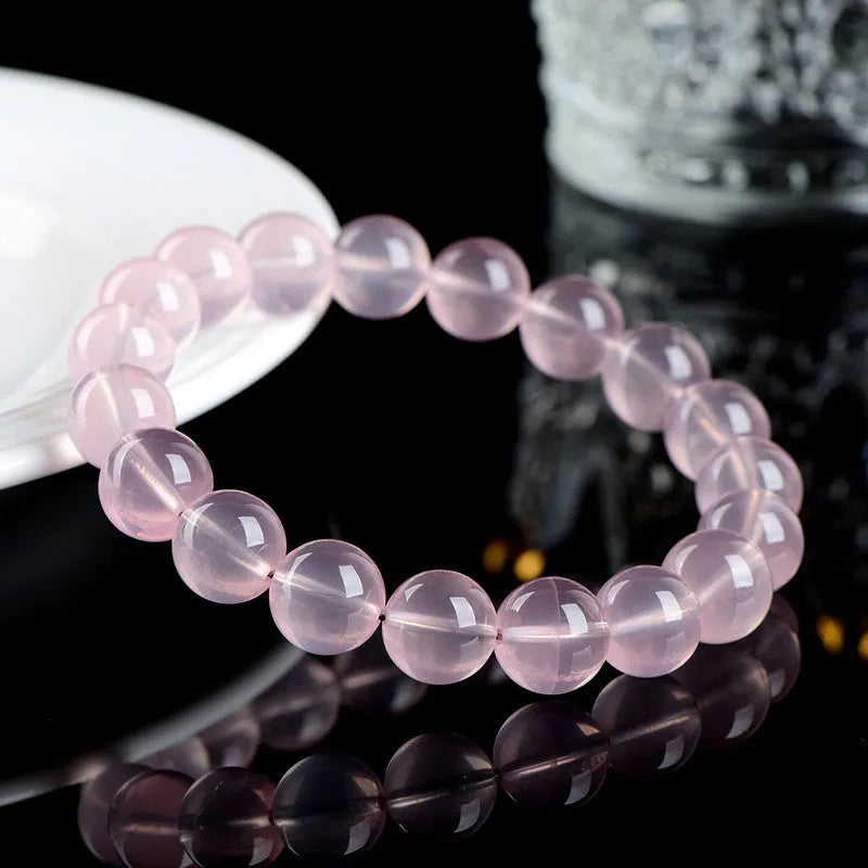 Natural starlight crystal bracelet with round polished pink beads in various size options.
