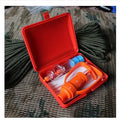 Orange portable venom extractor first aid kit with suction pump, two cups, tourniquet, and swabs laid out.
