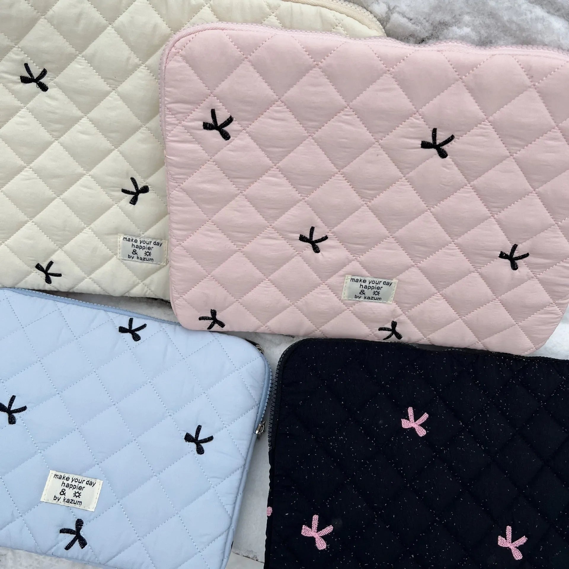 Nylon laptop storage bag with an embroidered rhombus bow in light pink colour.