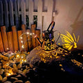 Tapered butterfly pattern iron solar garden lamp with warm white LED light.