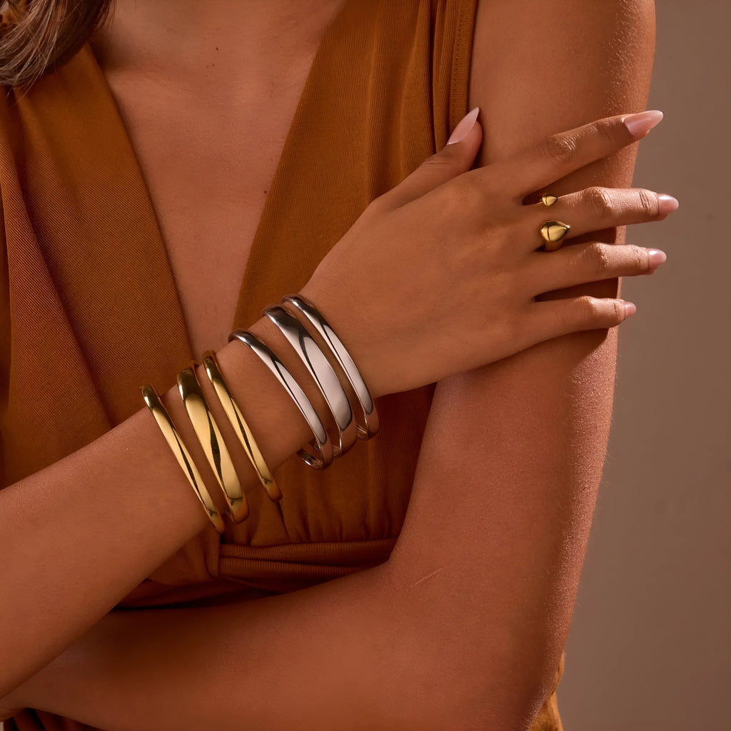 Geometric stainless steel women's bracelet with simple opening, available in gold or steel colour with linear design elements