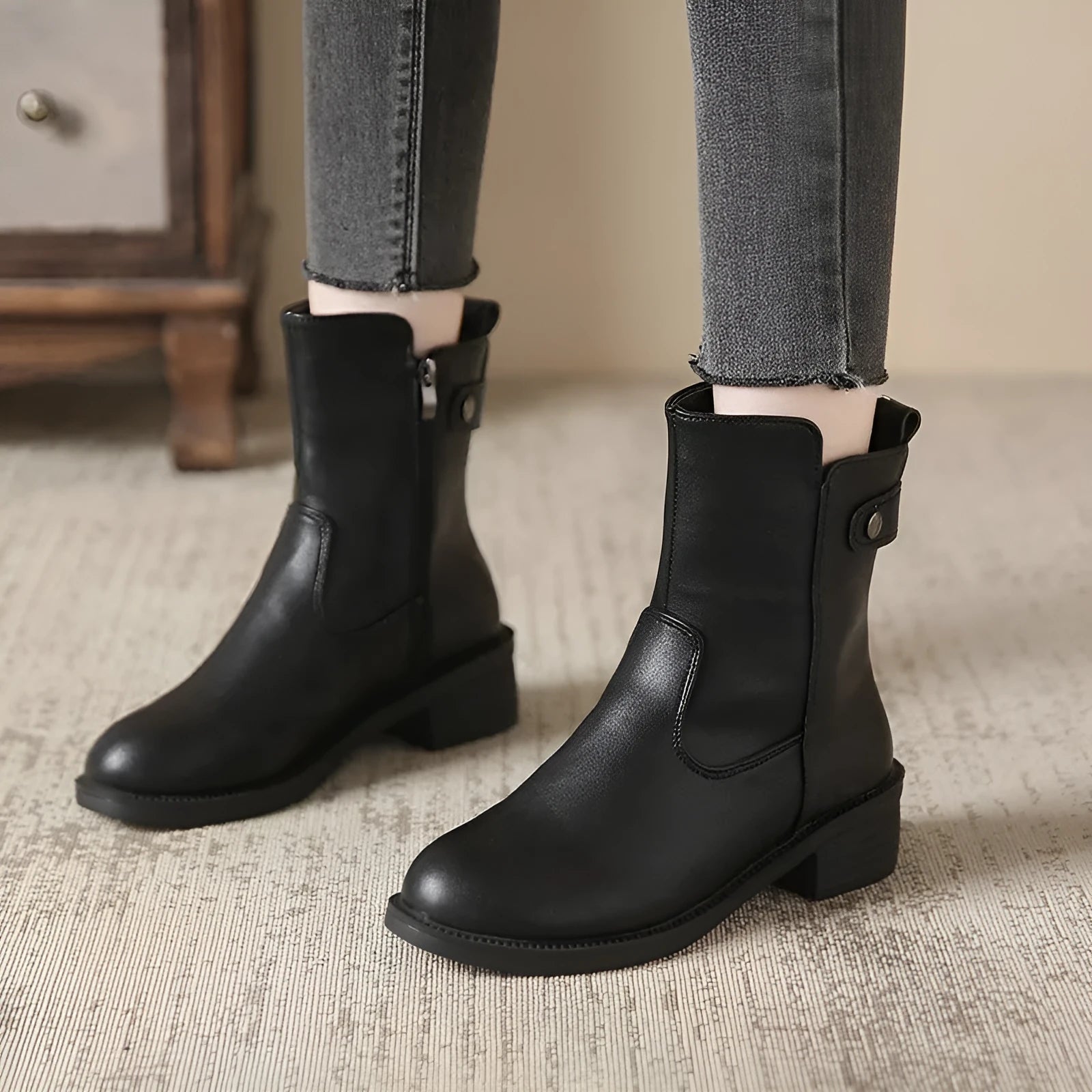 Black women's ankle boots with a round toe, side zip, and a low rubber sole.