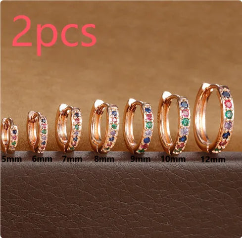 Set of gold, rose gold, and silver perforated circle stud earrings in multiple sizes on a flat surface.
