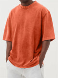 Man wearing a loose-fit, stone-washed grey t-shirt with a distressed solid colour finish and half sleeves.