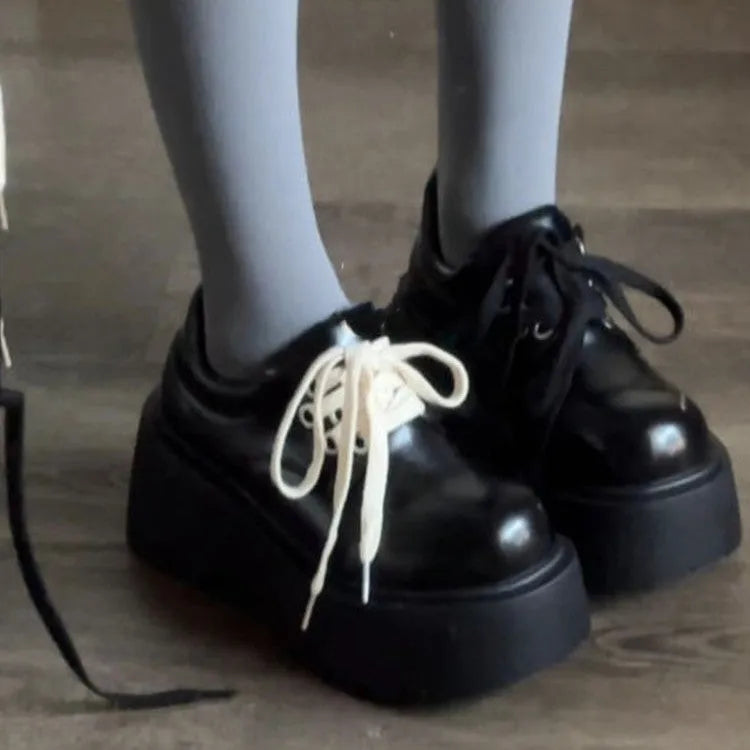 Black women's lace-up platform shoes with a chunky rubber sole and English muffin heel.
