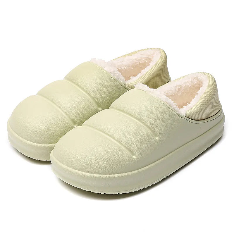 Green waterproof EVA garden slippers with plush lining and a non-slip sole, shown on a wooden deck.