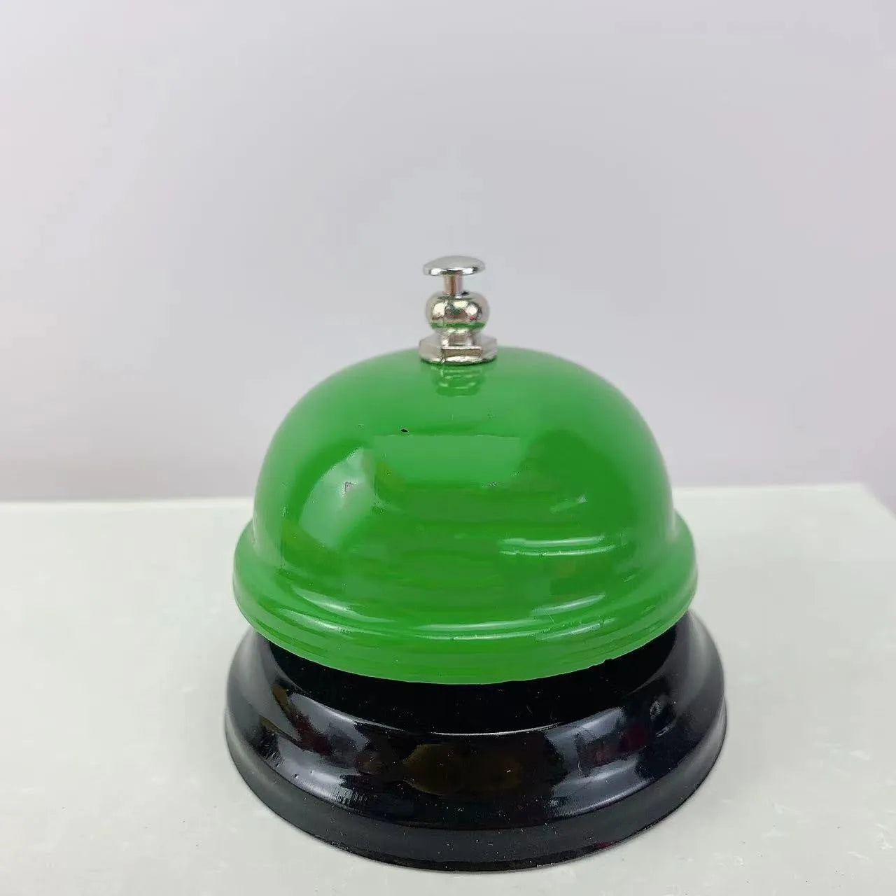 A multi-colour iron hand bell for games, classrooms, or restaurant service.