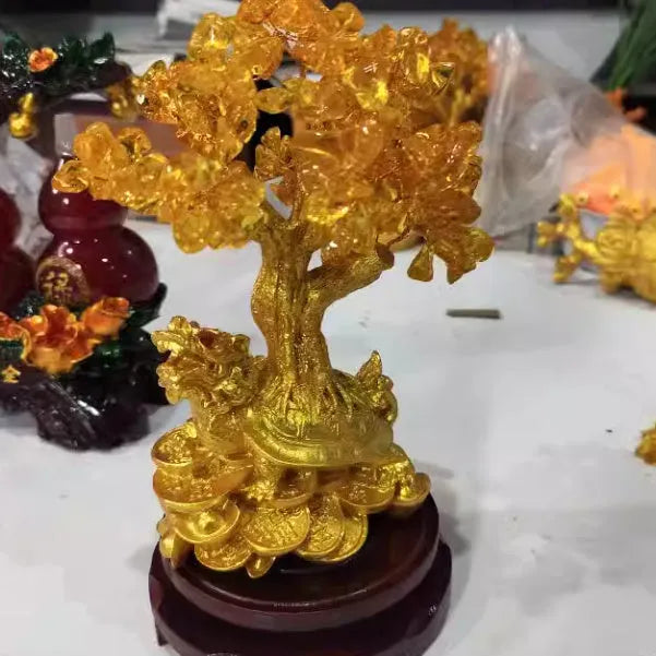 Citrine-coloured resin turtle money tree Feng Shui ornament on display.