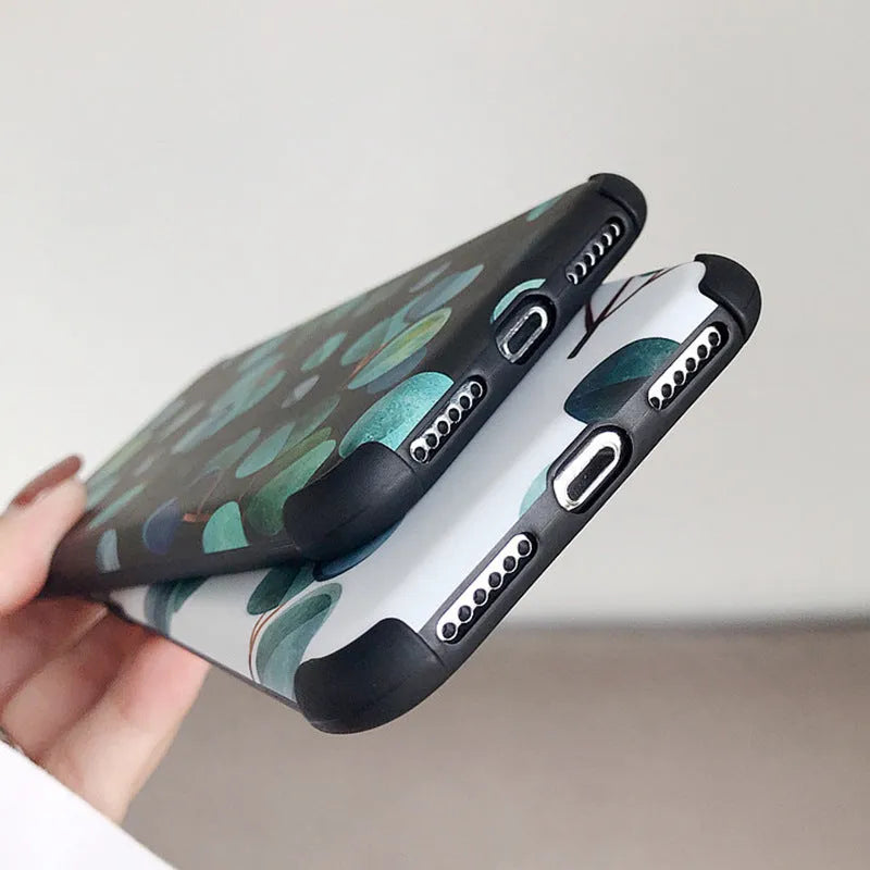 Black silicone iPhone case with a leaf pattern design on a table.