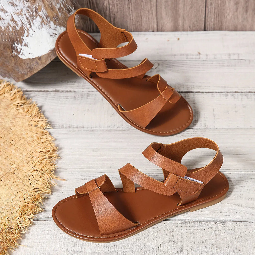 Women's flat casual sandals with Velcro strap in black, brown, or colourful PU with a rubber sole.
