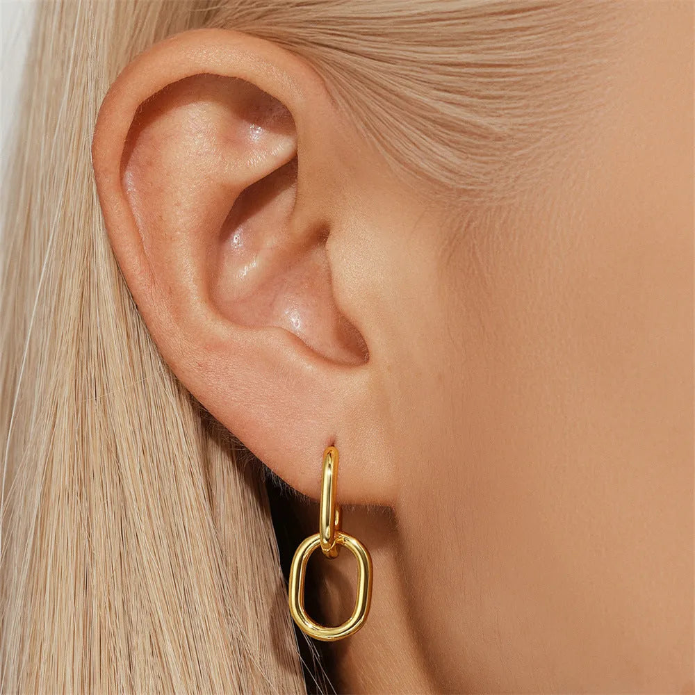 Geometric brass earclip earrings with round elements in golden and gold finishes