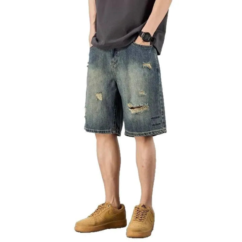 Blue retro-style men's denim shorts with a loose fit, distressed holes, and a straight-leg cut.