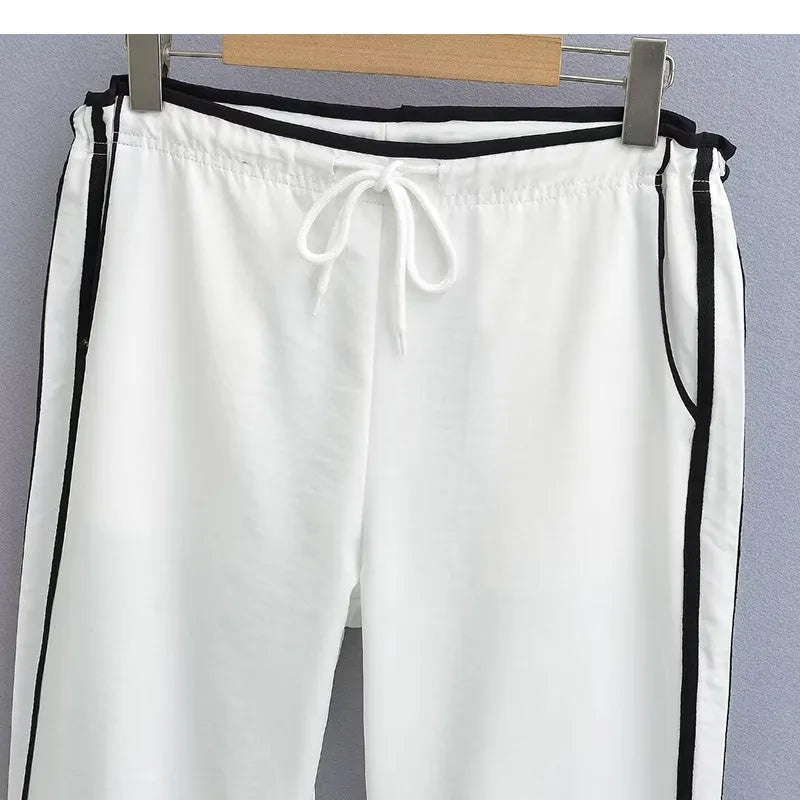 Navy blue loose straight-leg trousers with contrast ribbon trim and a slimming drape