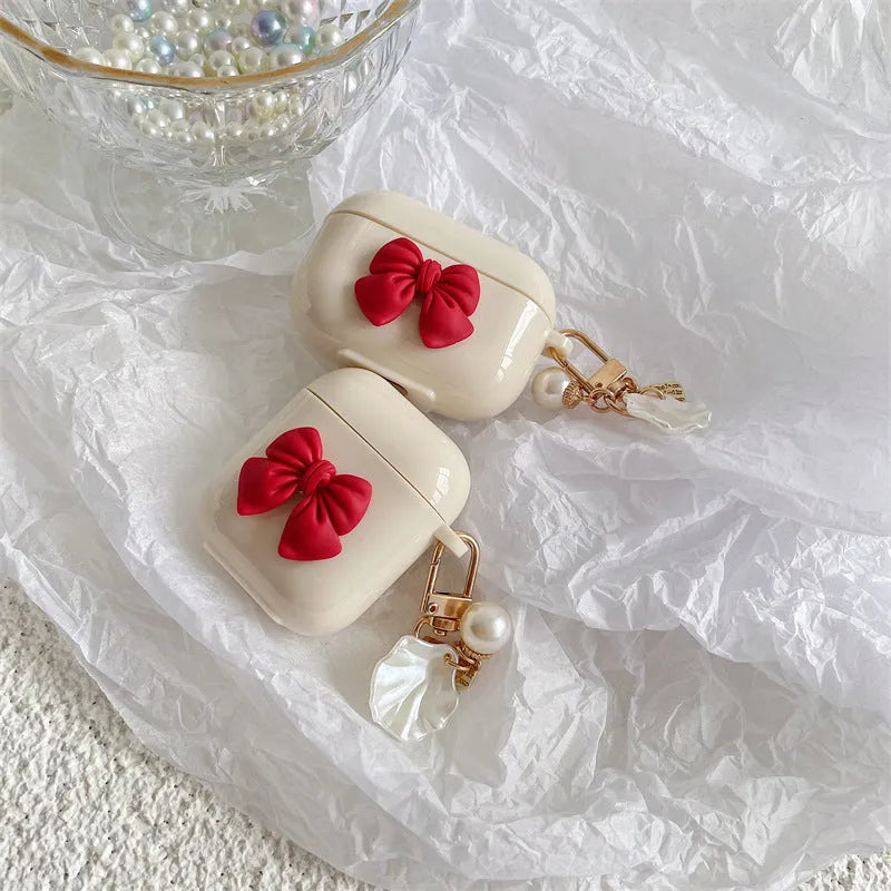 Beige AirPods case with red bow shell design, clamshell TPU earphone cover