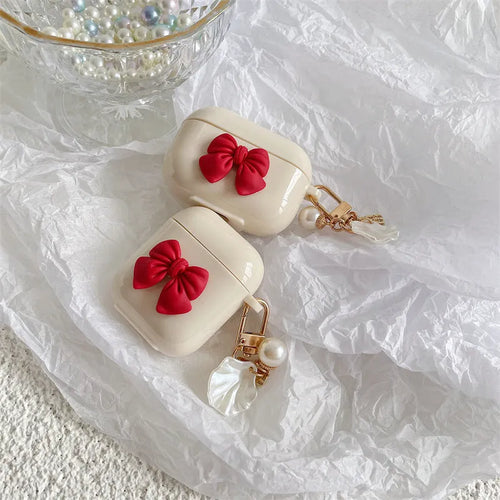 Beige AirPods case with red bow shell design, clamshell TPU earphone cover