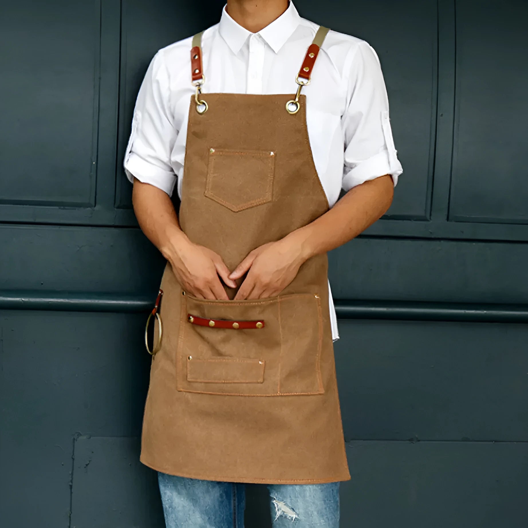 Canvas cross strap apron in camel colour shown from the front.