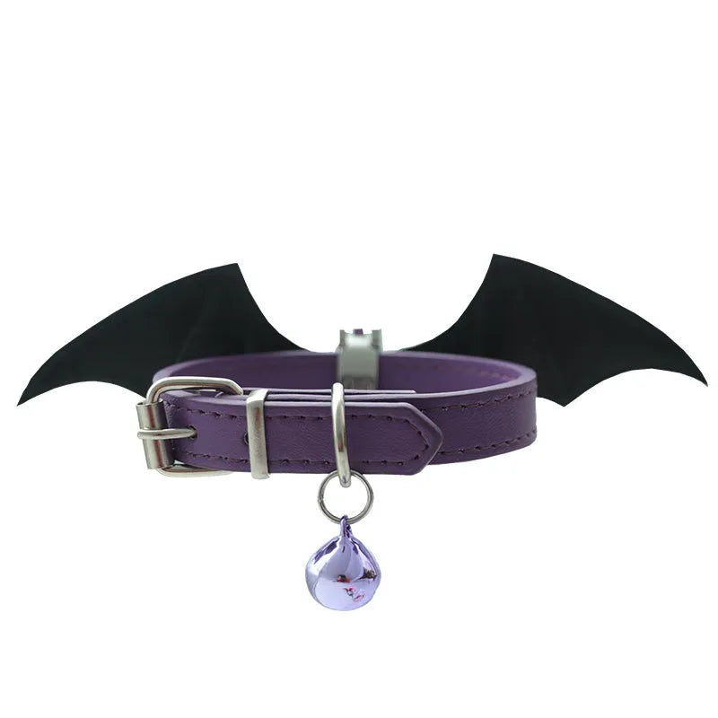 Small black patent leather dog collar with little devil wings charm and bell attached.