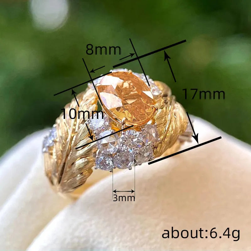 Gold-coloured embossed feather ring for women with an inlaid yellow zircon stone.