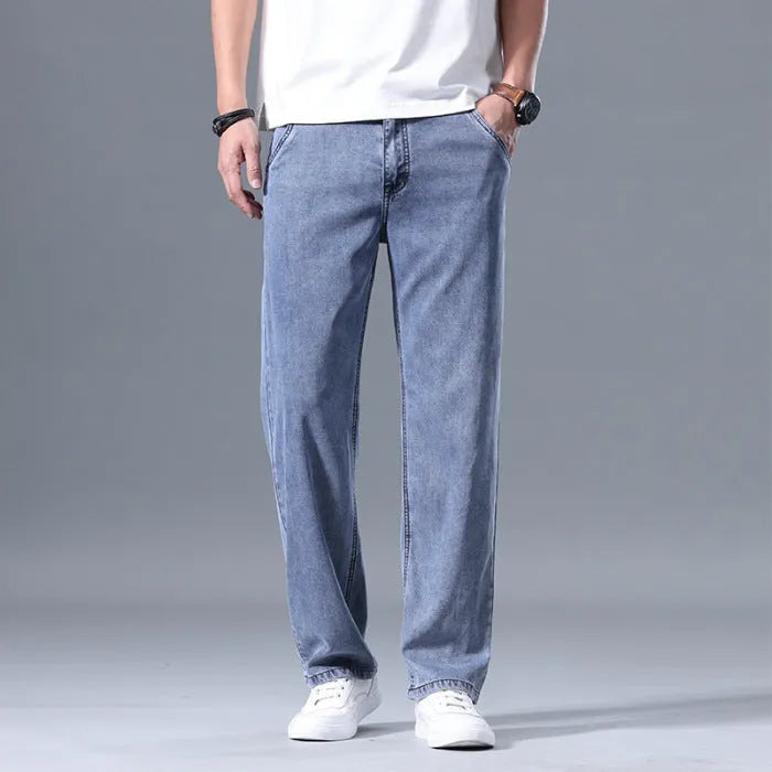 Man wearing light blue loose straight-leg lyocell jeans on a casual background.