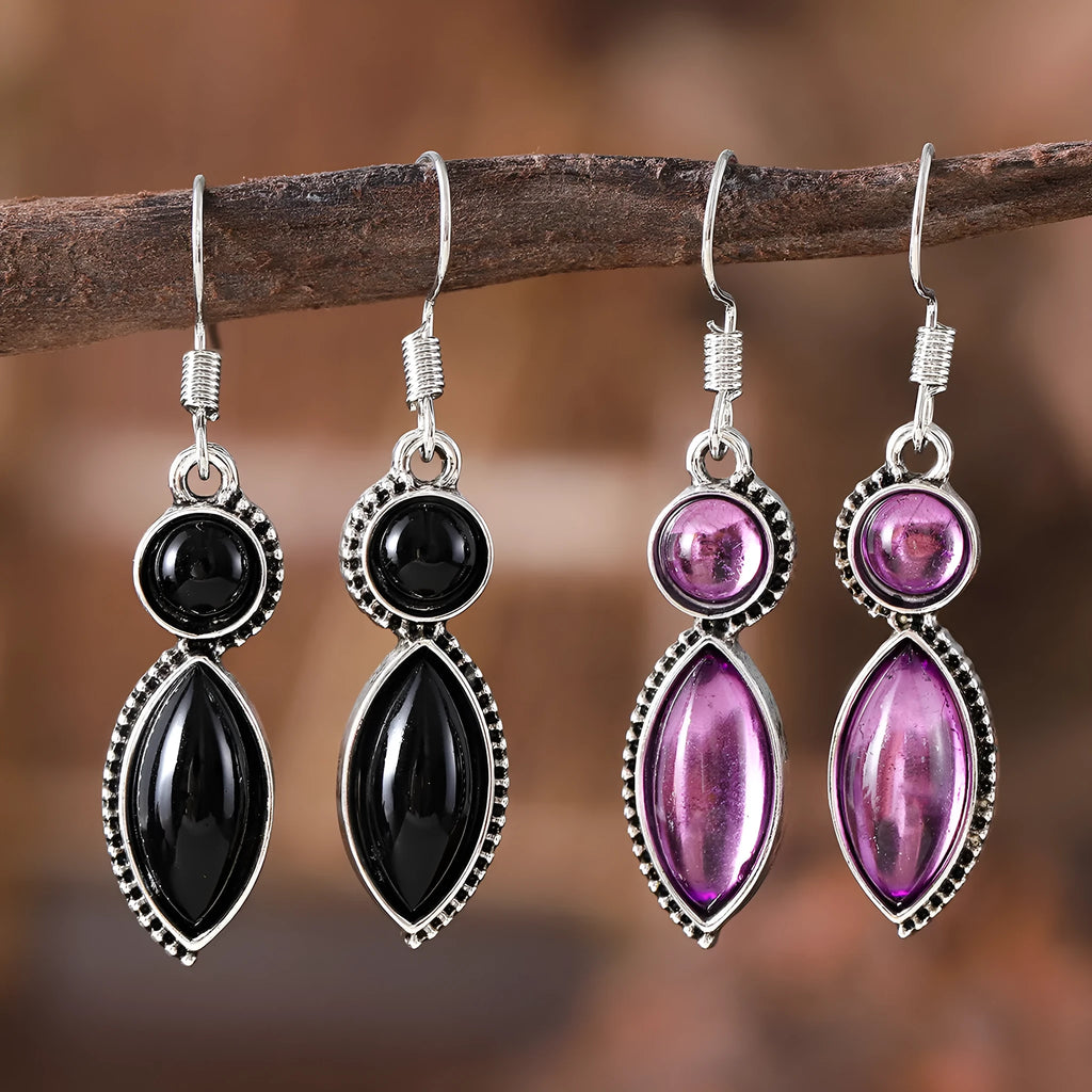 A pair of geometric vintage earrings with a black and purple electroplated finish, showing a pendant design with round elements.