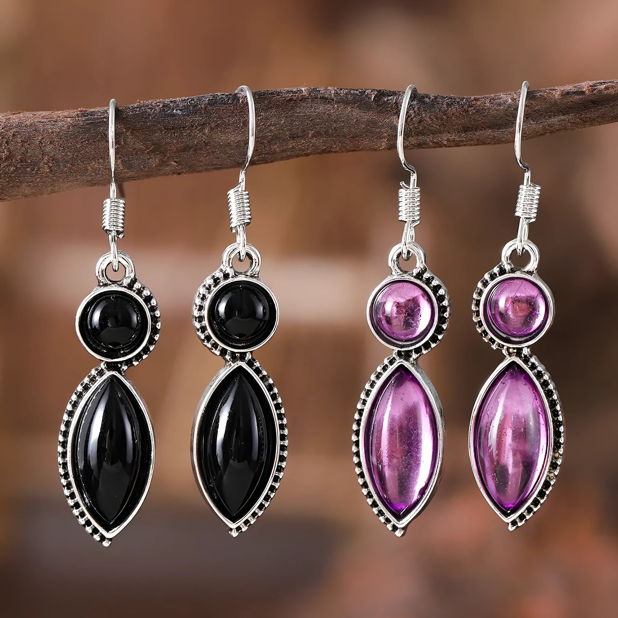 A pair of geometric vintage earrings with a black and purple electroplated finish, showing a pendant design with round elements.