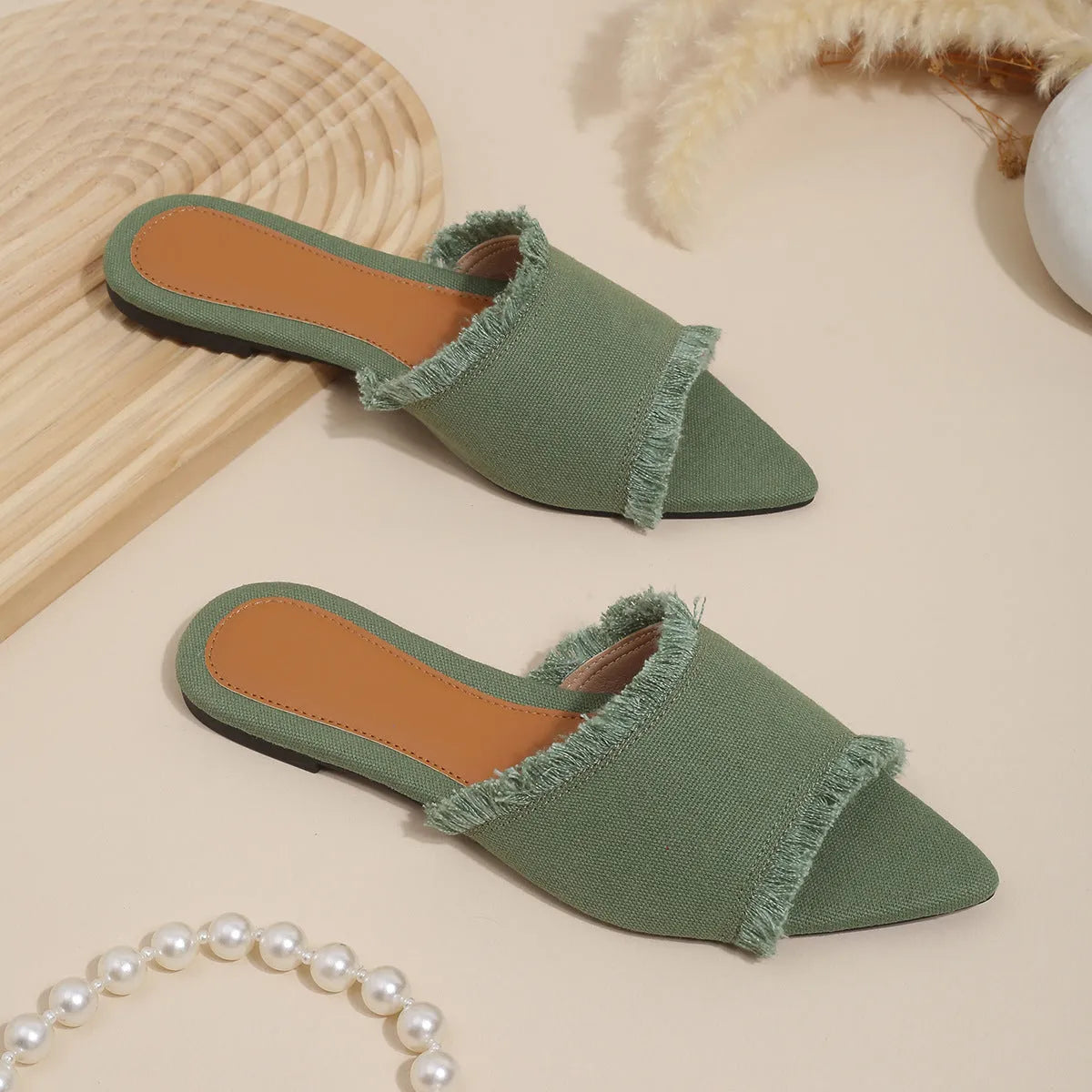 Solid colour denim women's slippers with a tassel detail, showing leather lining and PVC sole.