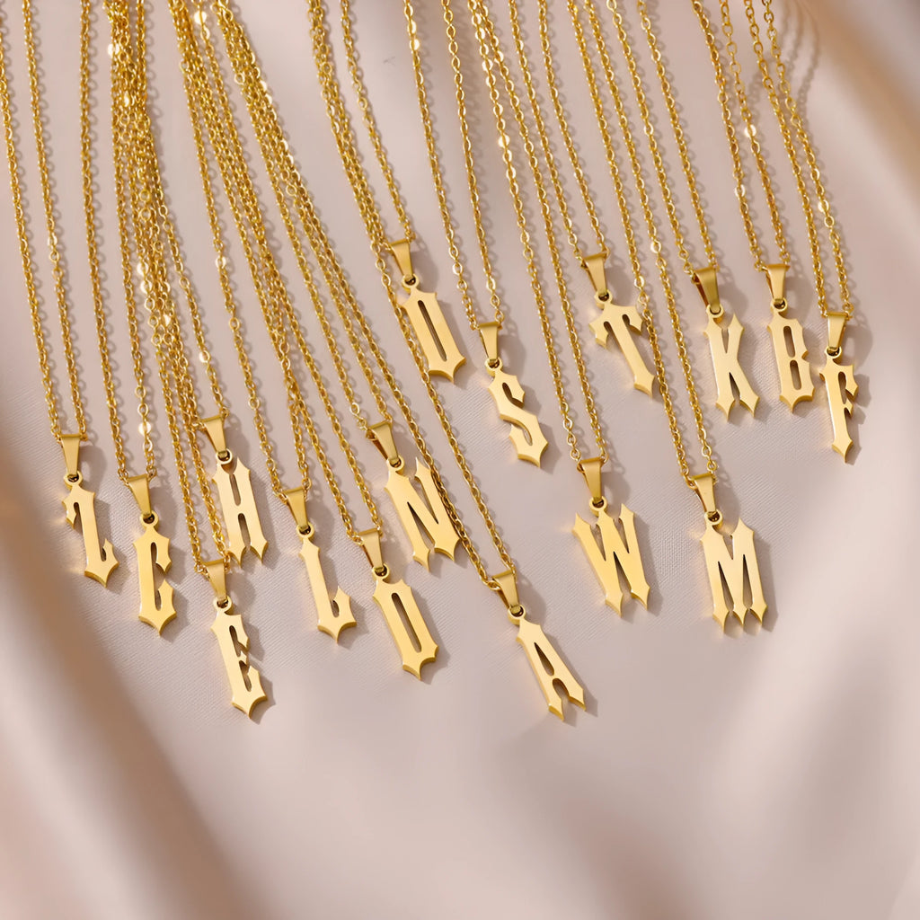 Gold stainless steel ancient English letter pendant necklace with O-ring chain on white background