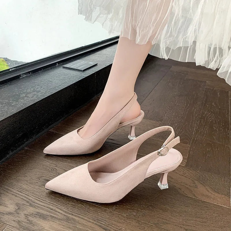 Apricot suede stiletto high heels with a pointed toe and rubber sole on a plain background.